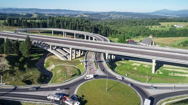 New highway and tunnel under construction in Poland on national road no 7, E77, called Zakopianka, in July 2020. Traffic circle and slip roads. Aerial video. Far view of Tatra Mountains and Babia Gora