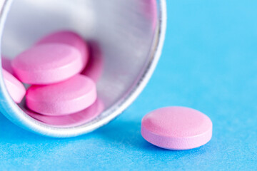 Macro photo of pink pills on blue background