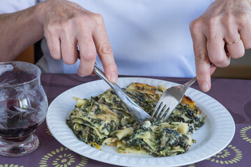 Cortando lasaña de verduras