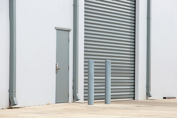 Grey warehouse roller door entry with security bollards