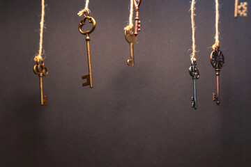 Fototapeta na wymiar A lot of different old keys from different locks, hanging from the top on strings.