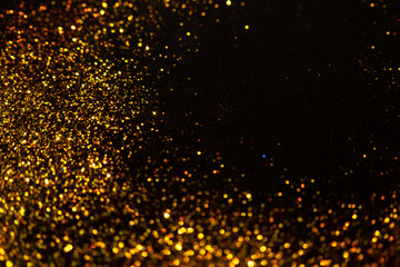 Sparkling gold glitter on a black background, magic abstract background. Round frame made of gold particles,