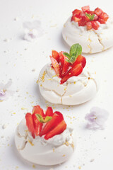 Homemade meringue dessert Pavlova cake with fresh strawberries and mint. Summer dessert. French cake. Confectionery. Classic dessert. Strawberry dessert