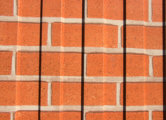 Red brick background. Brickwork with black and white seams. Building stone for residential building...