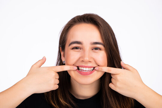 Pretty Woman Stretching The Corners Of Her Mouth And Making Smile