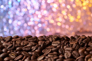 Obraz premium Heap of roasted brown whole coffee beans with a blurred red and blue background
