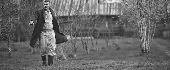 vintage man young village black and white, eastern europe style, retro coat and boots