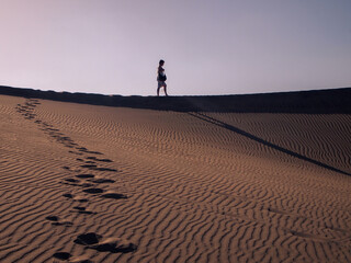 man walking on the sand dunes