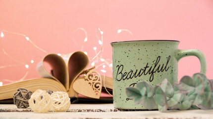 Mint tea mug. On the mug is the inscription of a beautiful day. Nearby lies an open book with...