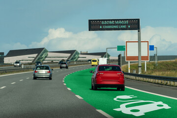 Road with lane for wireless charging of electric vehicles - obrazy, fototapety, plakaty