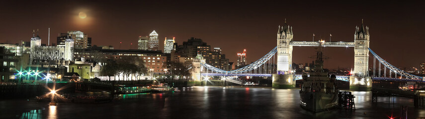 Naklejka premium Panoramic skyline cityscape at night of the River Thames London England UK showing thr Tower of London, Tower Bridge and HMS Belfast all popular travel destination tourist attraction landmarks