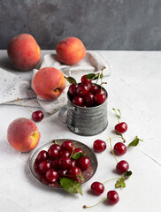 Naklejka na ściany i meble Ripe cherries metal plate and mug and peaches on the table