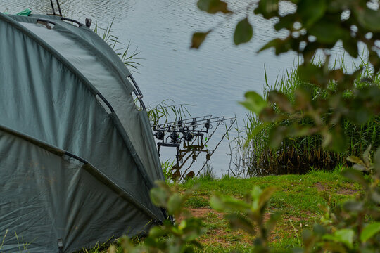 Tent and fishing equipment on a lake.