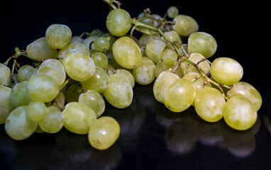 Sweet green grapes on a black background