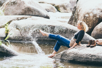 Woman with backpack having rest while hiking in the river valley