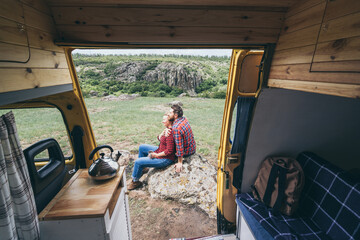 Fototapeta na wymiar Young couple travelling by campervan though the countryside