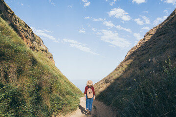 Woman with backpack hiking in the mountains