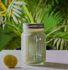 Healthy smoothie drink in glass jar,with a tropical background.