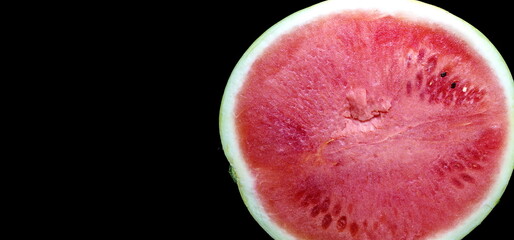 Half of ripe fresh juicy watermelon on a black background