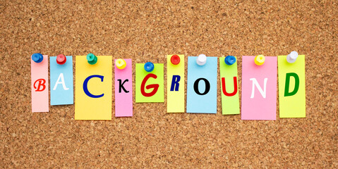 Multicolor notes with letters pinned on a cork notice board.