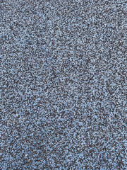 Black and light blue shock absorbing rubber crumb coating. color grainy background texture. soft coating for recycled rubber sports and playgrounds