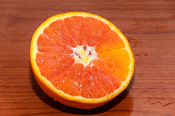 Half orange jucy fruit, close up, wood background