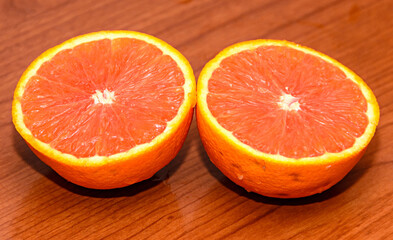 Half orange jucy fruit, close up, wood background