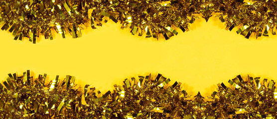 Christmas background. yellow tinsel Christmas decoration seamless isolated on yellow background. 