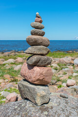 Stack of stones on stone sand beach with sea background. Zen garden. Rock tower.