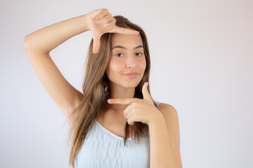 Fototapeta premium Pretty young girl making the portrait gesture