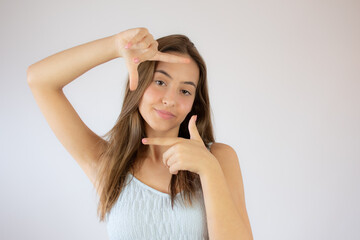 Fototapeta premium Pretty young girl making the portrait gesture