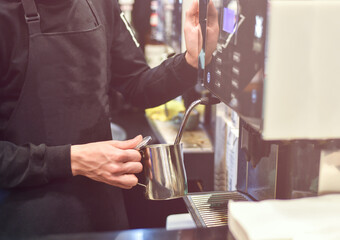 Barista hand preparing milk for cappuccino