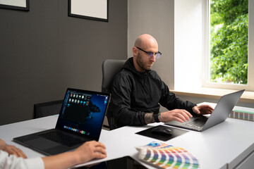 We already have great results. Young beautiful woman smile and discussig something with her coworker while standing at office with laptop