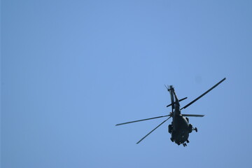 Fototapeta na wymiar helicopter flies against the blue sky. back view