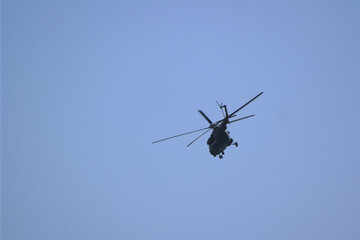 Fototapeta na wymiar helicopter flies against the blue sky. back view