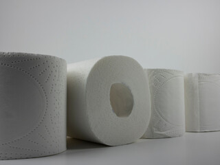 rolls of white toilet paper on a white table.