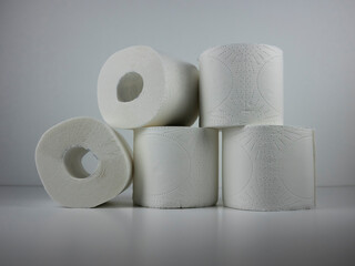 rolls of white toilet paper on a white table.