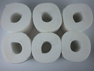 rolls of white toilet paper on a white table.