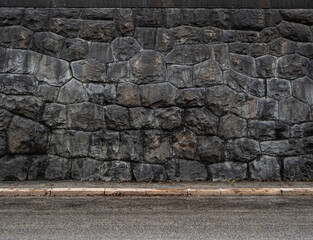 Stone wall by a paved street
