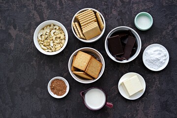 Ingredients for dessert, chocolate salami on a dark concrete background