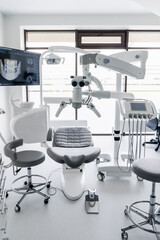 Interior of dental practice room with chair, lamp, display and stomatological tools