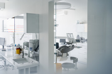 Interior of dental practice room with chair, lamp, display and stomatological tools