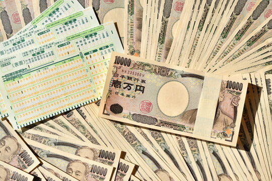 記入された競馬のマークカードと札束