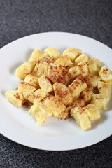 Gnocchi. Small soft dough dumplings with cottage cheese, honey and cinnamon on plate.