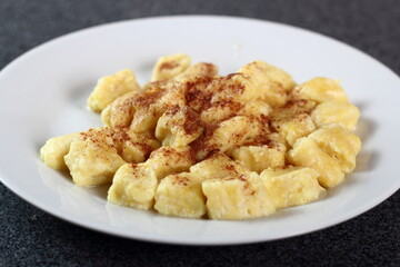 Gnocchi. Small soft dough dumplings with cottage cheese, honey and cinnamon on plate.