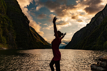 Eine Frau fühlt sich glücklich am Fjord