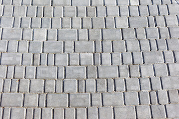 Decorative colorful sidewalk pavement. Tiled floor with grey tiles crossed by a diagonal double stripe of red tiles viewed at a low angle, full frame background pattern