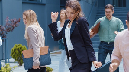 Excited multi-ethnic co-workers dancing on the street celebrating triumph in business career success cooperation. Staff. Holiday concept.