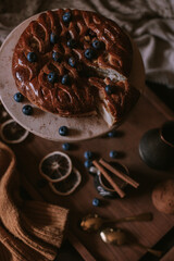 Still life of apple pie, berries, coffee and lemons on wooden tray