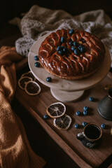 Still life of apple pie, berries, coffee and lemons on wooden tray